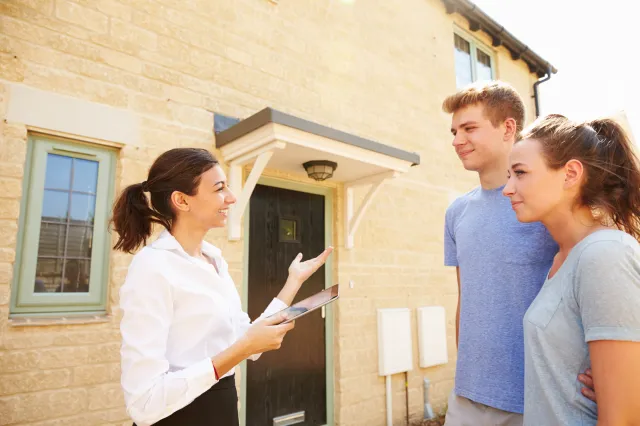 Young couple viewing a house with a real estate agent