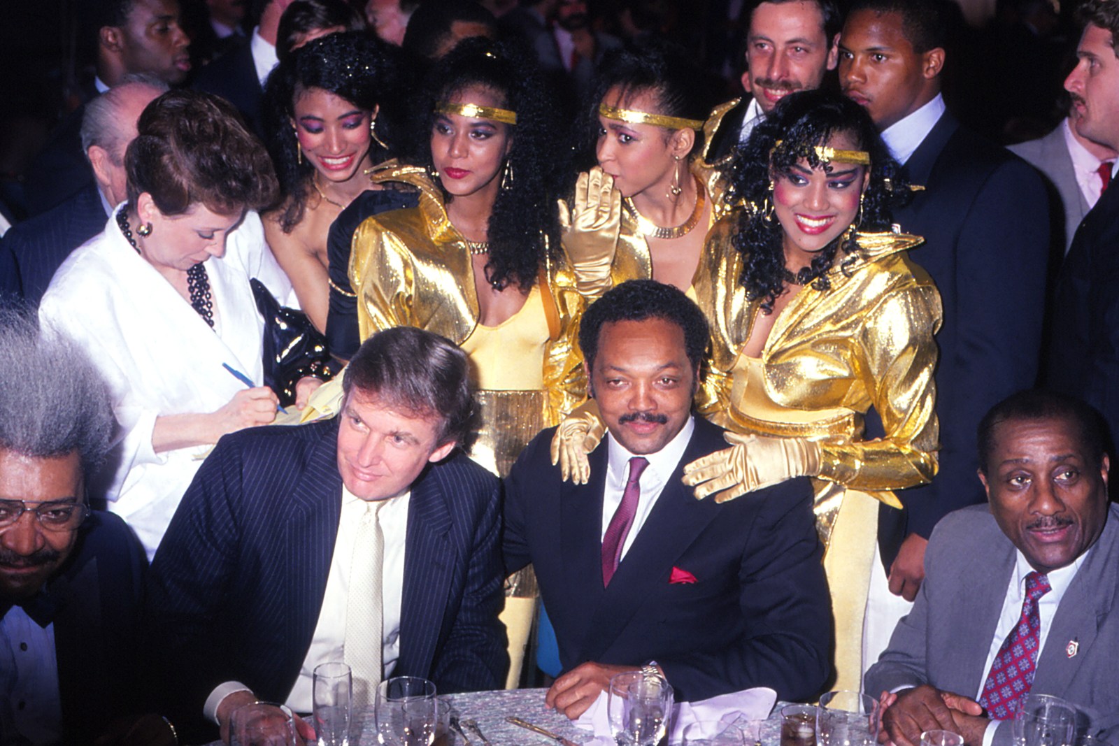 Donald Trump and The Reverend Jesse Jackson with unknown singers from hotel lounge act at Tyson vs Holmes pre fight party at Trump Plaza Casino Hotel in Atlantic City, New Jersey January 22 1988. (Photo by Jeffrey Asher/ Getty Images)