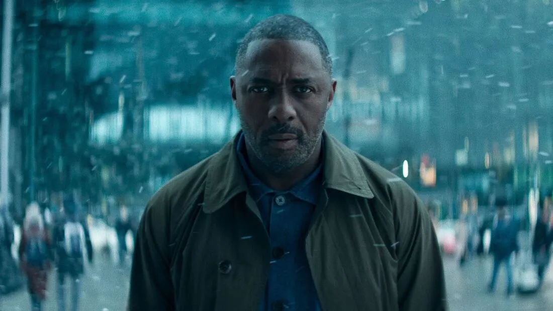 A man stands in a busy street with a concerned expression.