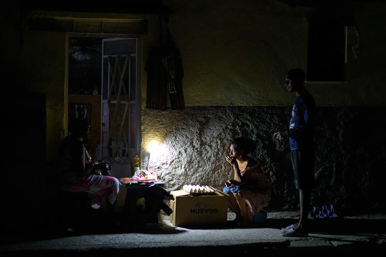 Street vendors chat during a blackout in Havana, on March 16, 2026.