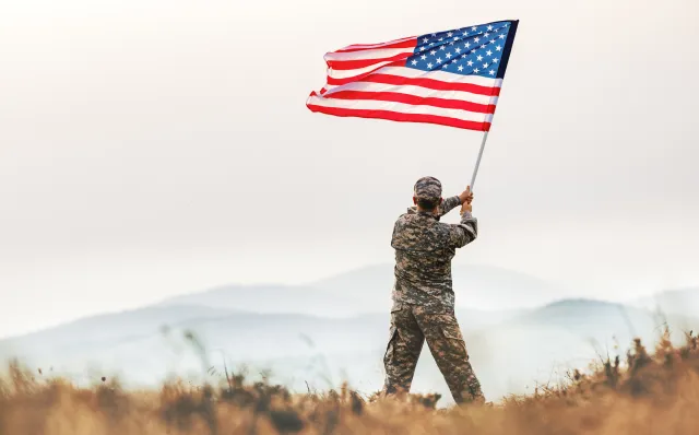 Stock image/file photo: Veteran waving American flag.