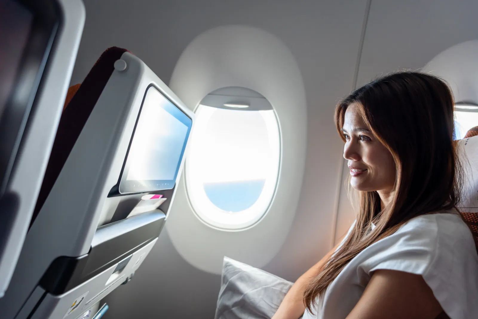 Woman watching a video screen on a plane.