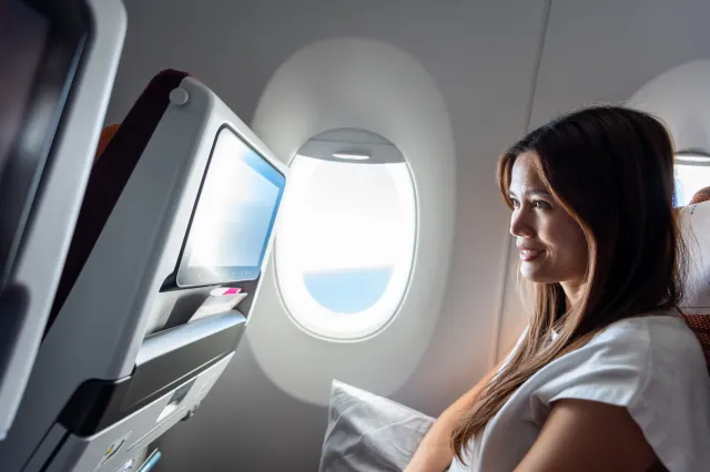 Woman watching a video screen on a plane.