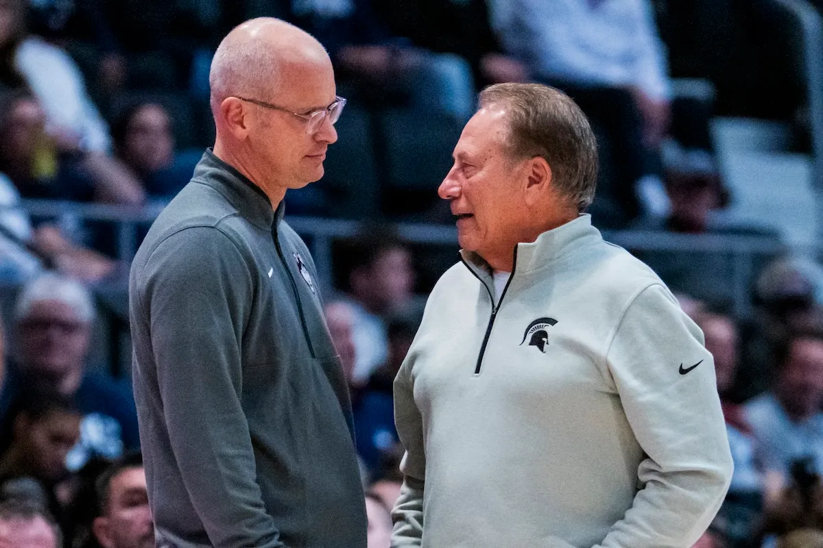 Dan Hurley and Tom Izzo chat during a UConn and Michigan State basketball game