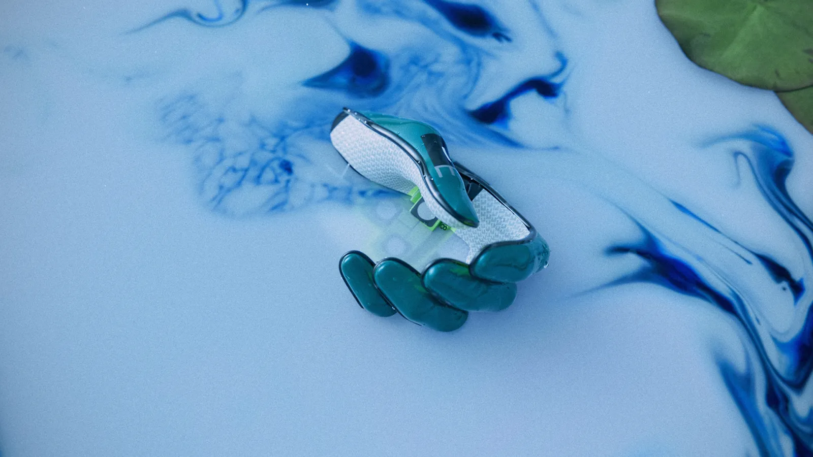 A robotic hand partially submerged in swirling blue and white liquid.