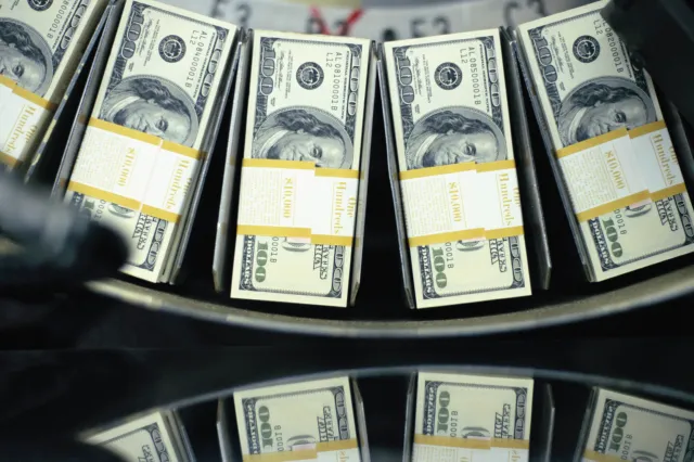 File image: Bundles of freshly printed $100 bills roll through a conveyor belt at the United States Department of Treasury - undated