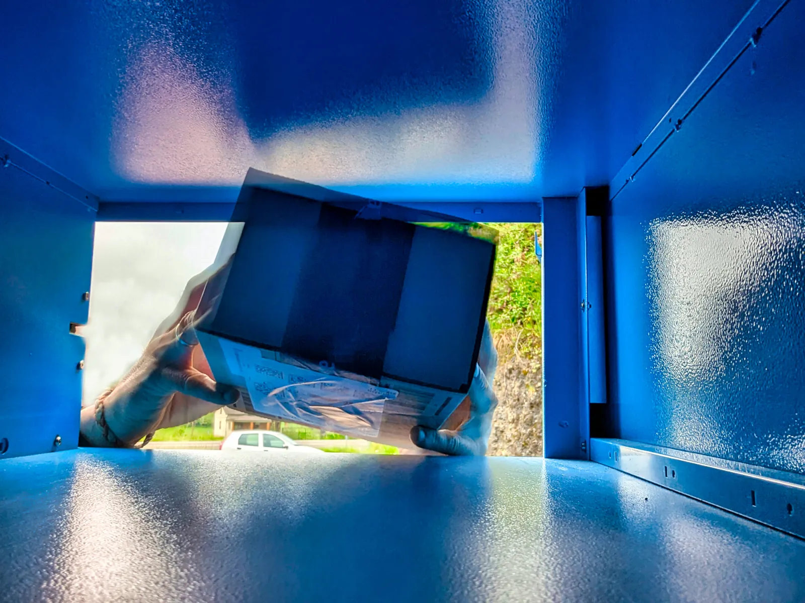 Stock image: Two hands picking up a package deposited in a locker. Getty Images