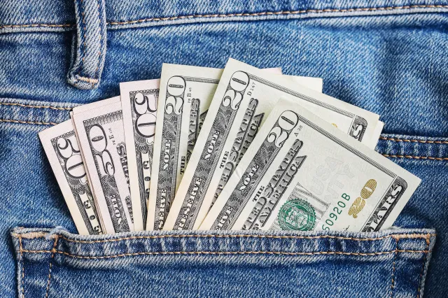 Stock image of U.S. dollars in a jean pocket.