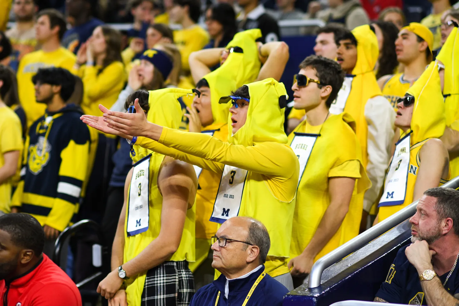 Fans of the Michigan Wolverines react to a call during the first half of a college basketball game.