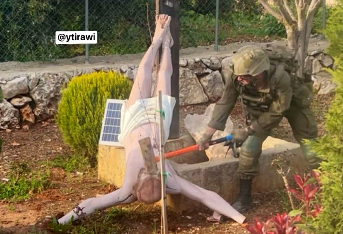 Photo showing IDF soldier striking a statue of Jesus Christ with a sledgehammer in the village of Debel in southern Lebanon