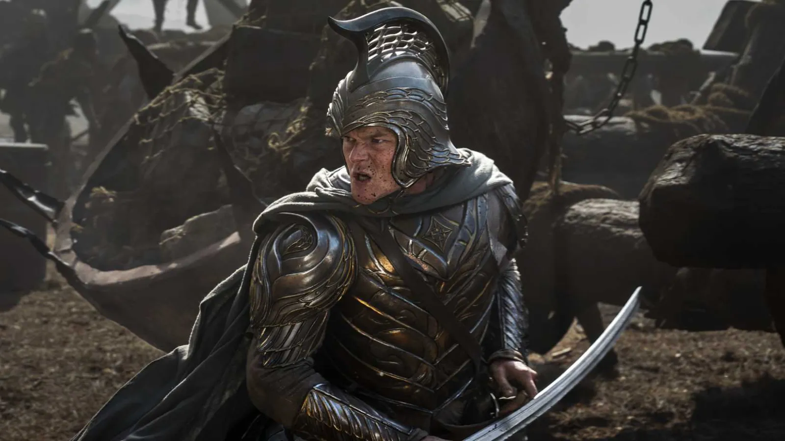 A man in silver fantasy armor fighting foes on a battlefield