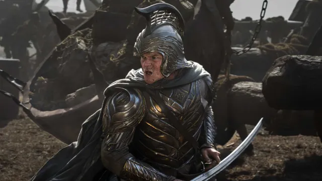 A man in silver fantasy armor fighting foes on a battlefield