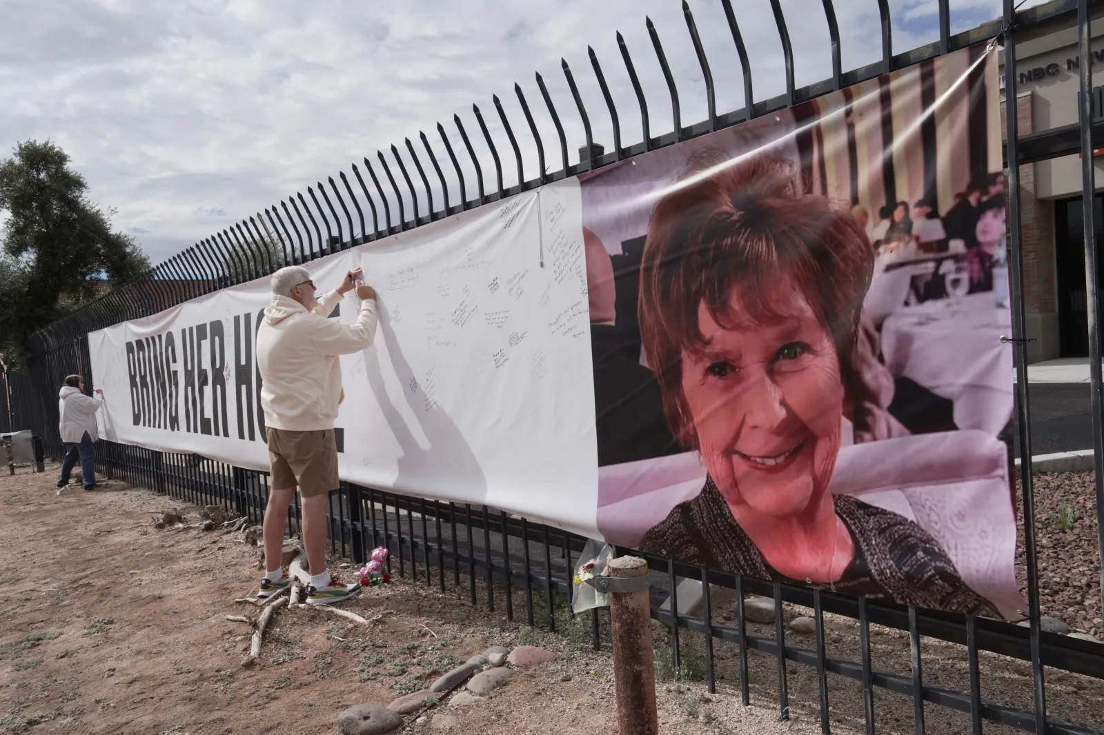 Jeff Robb, a Seattle resident wintering in Tucson, signs a banner supporting Nancy Guthrie in Tucson on February 13. (AP Photo/Ty ONeil)