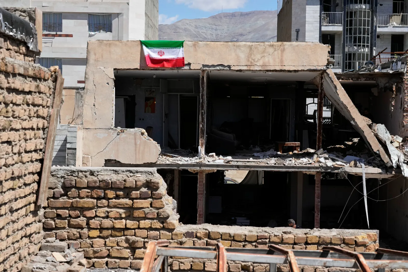 An Iranian flag hangs from the roof of a residential building damaged by recent U.S.-Israeli strikes in Fardis, west of Tehran, Iran, on April 3, 2026. (AP Photo/Vahid Salemi)