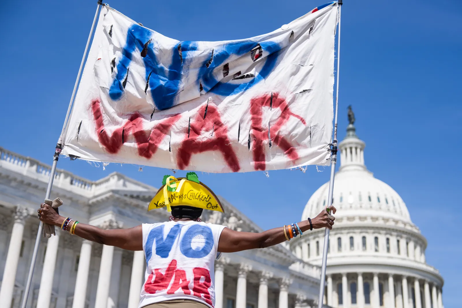 UNITED STATES - APRIL 9: A demonstrator holds a banner outside the U.S. Capitol after House Democrats unsuccessfully attempted to pass a resolution to stop the war in Iran, on Thursday, April 9, 2026. (Tom Williams/CQ Roll Call via AP Images)