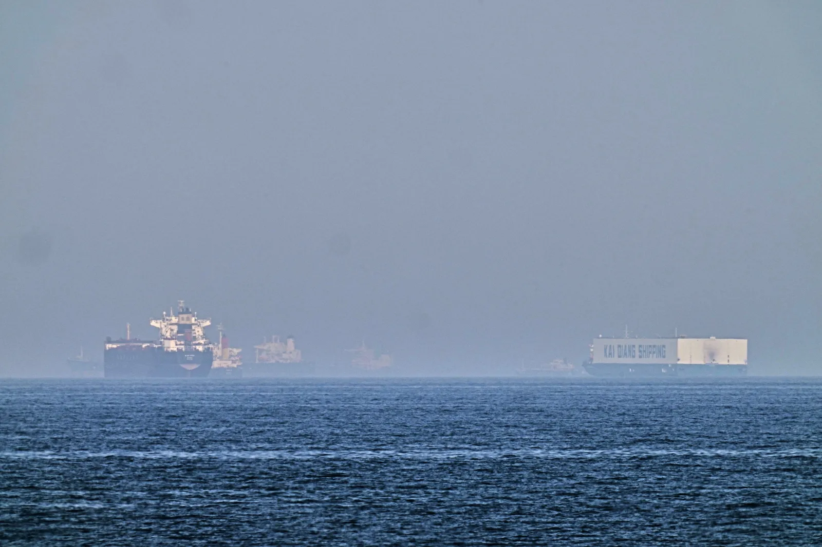 A tanker, left, and a car carrier are anchored at sea in the Gulf of Oman near the Strait of Hormuz, as seen from the coast near Khor Fakkan, United Arab Emirates, Friday, May 1, 2026