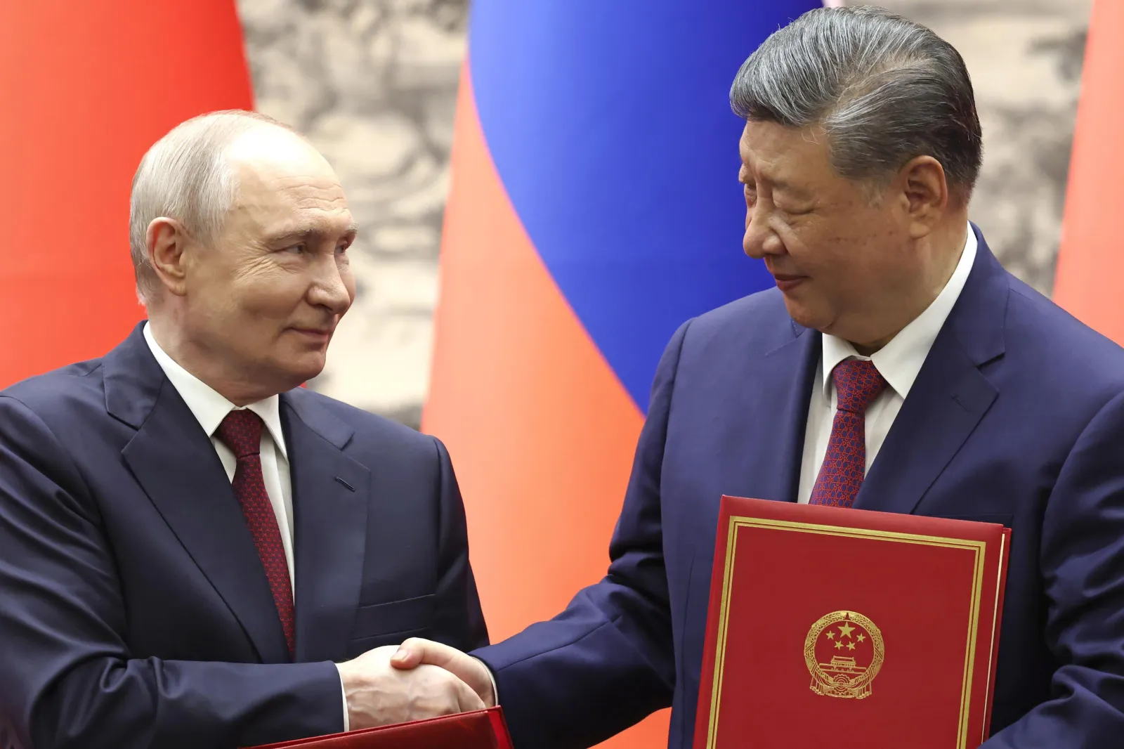 Russian President Vladimir Putin, left, shakes hands with Chinese President Xi Jinping during a signing ceremony at the Great Hall of the People in Beijing on May 20, 2026.