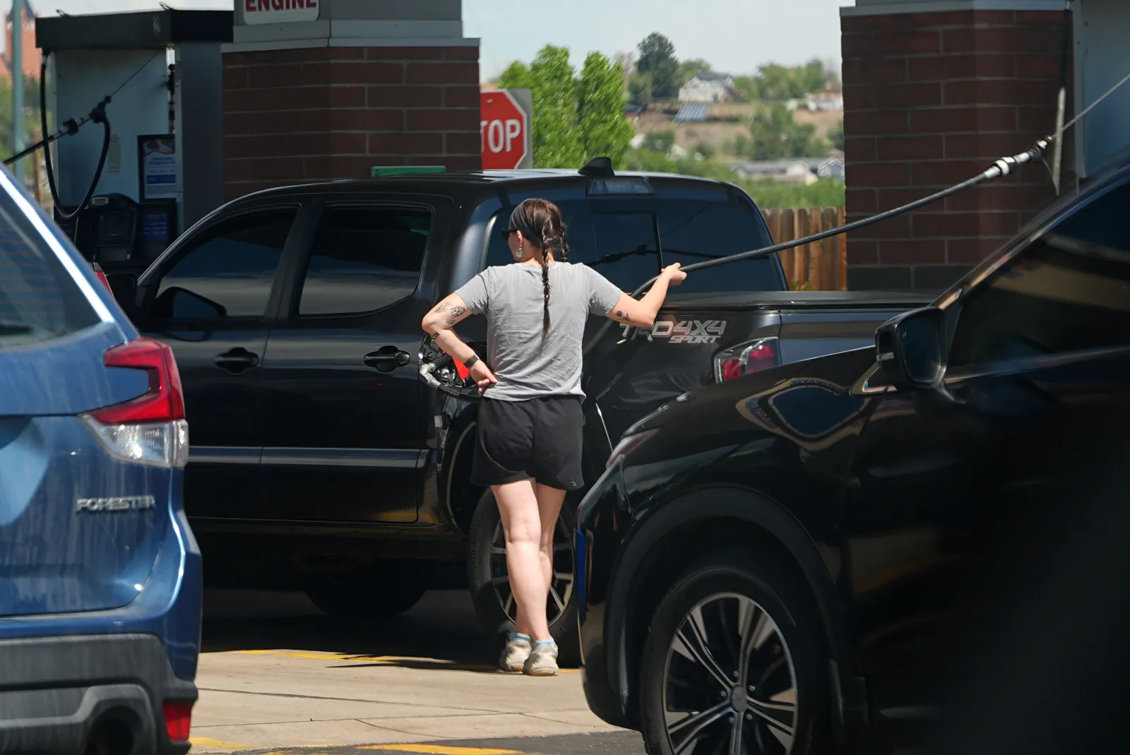 A motorist fills up the tank of a pickup truck as other motorists wait in line at a  gasoline station, on May 24, 2026, in Sheridan, Colorado.