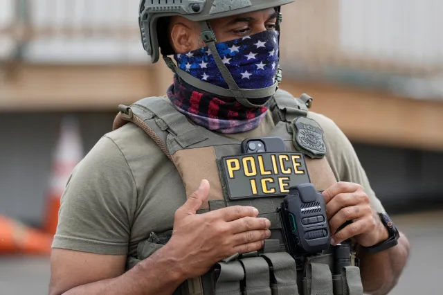 A masked ICE agent stands outside the Delaney Hall detention center during a protest against the transfer of detainees on May 27, 2026, in Newark, New Jersey.