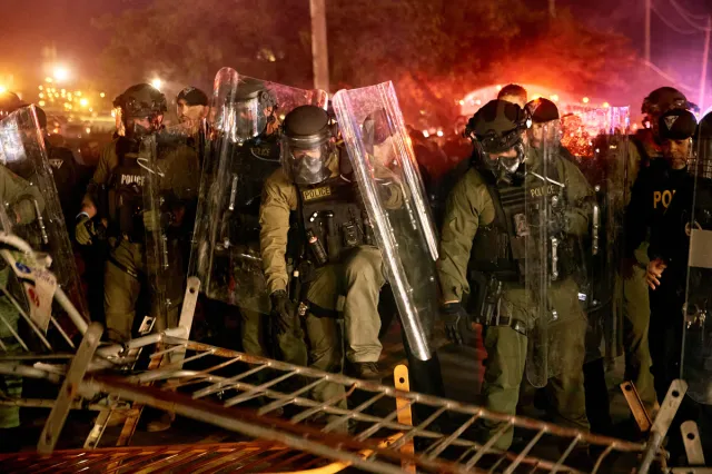 Police pass over a barricade as they clash with protesters near the Delaney Hall detention center during a protest against the transfer of detainees and federal immigration policies on Saturday, May 30, 2026, in Newark, N.J.