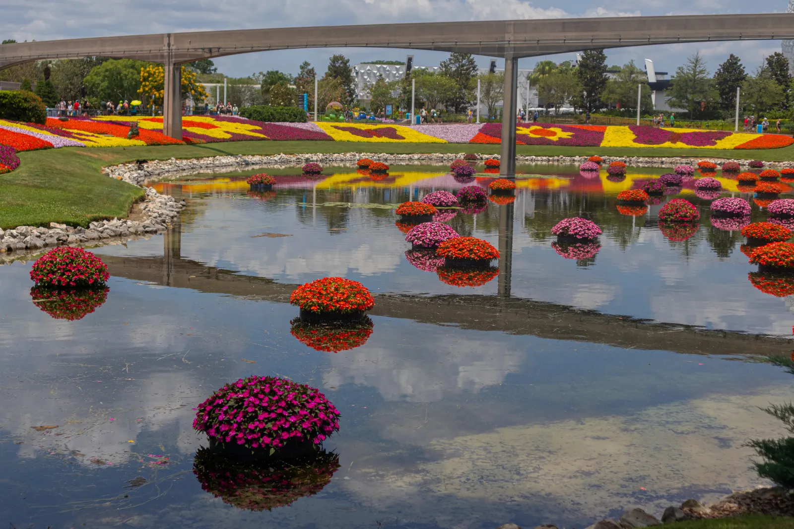 Epcot lake with multicolored flowers in May 2025.