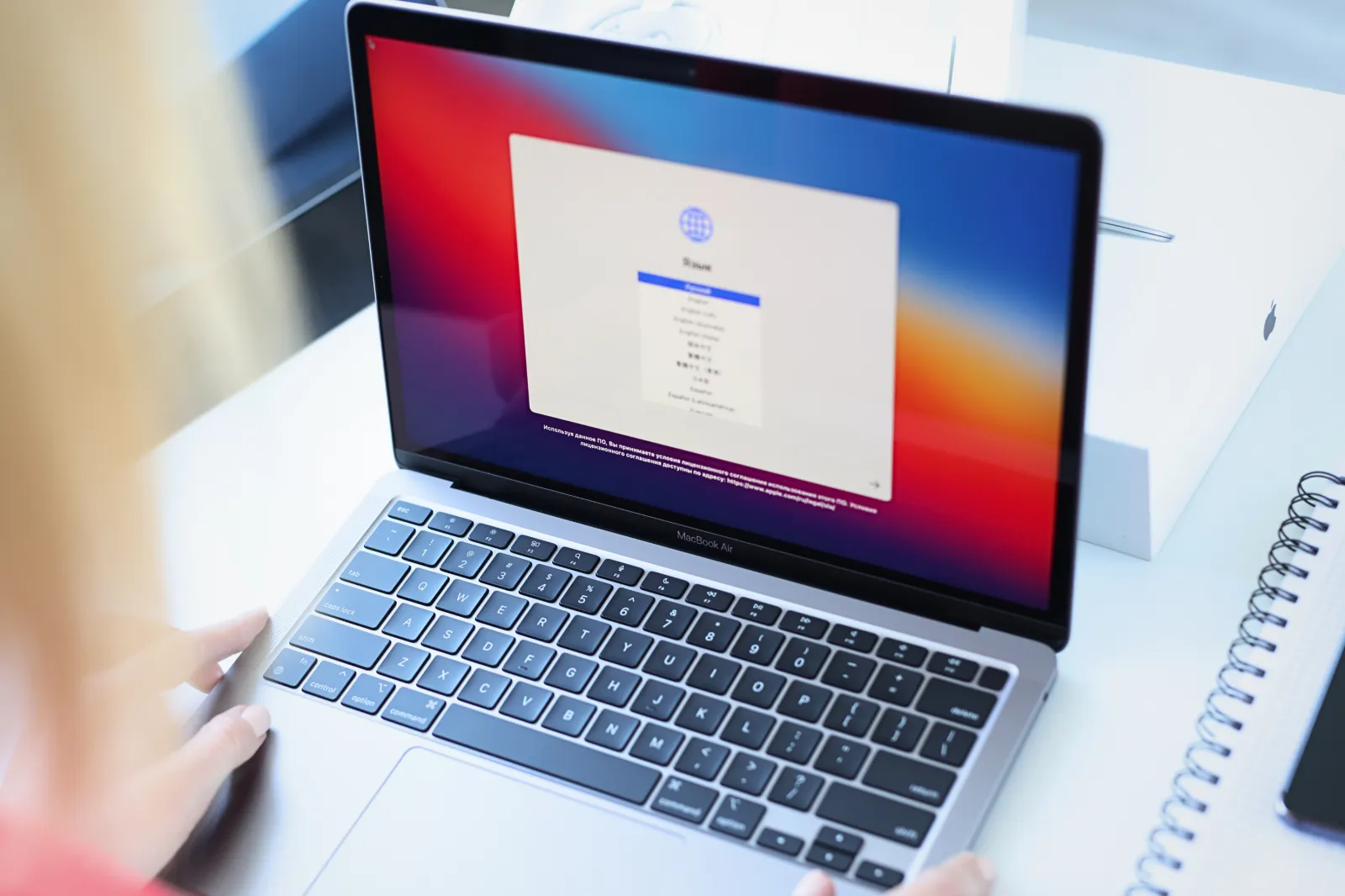 October 8, 2021: Woman choosing language on new laptop Apple MacBook air closeup - stock image