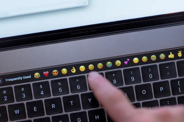 Stock image: Gothenburg, Sweden - November 30, 2016: Close-up of a mans hand using the touch sensitive bar of the keyboard on a new Apple MacBook Pro 15”, a laptop computer released by Apple Inc. in late 2016.