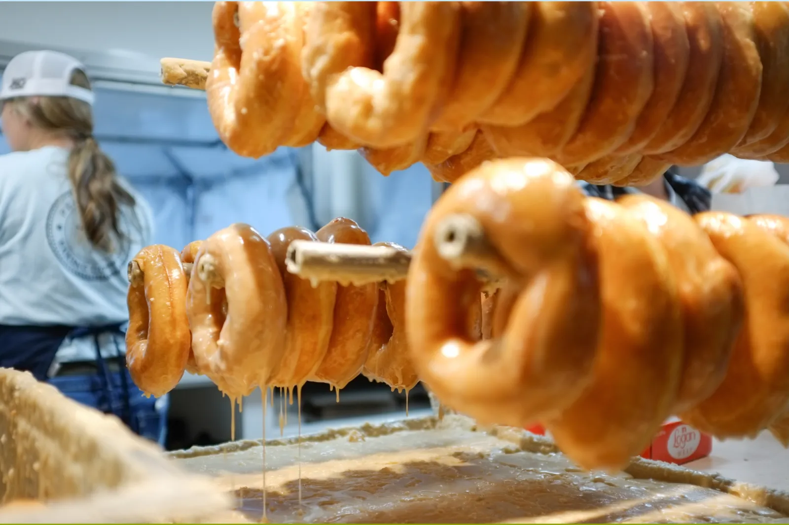 Freshly glazed donuts hanging from rack in North Carolina in 2019 | Getty Images