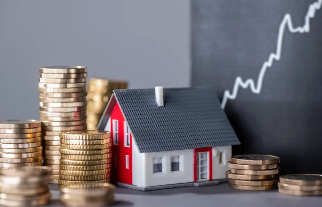Stock photo: House with stacks of money and a rising curve symbolizing rising real estate prices.