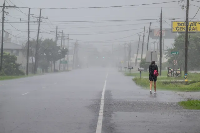 A person walks through pouring rain during a storm in Houma, Louisiana, on September 11, 2024.