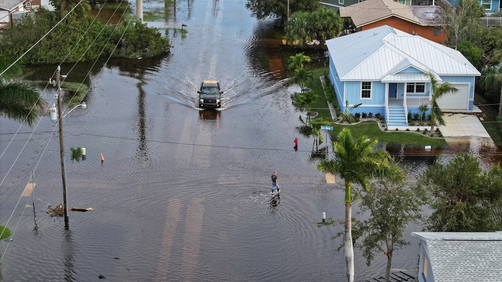 A person walks through floodwaters that inundated a neighborhood after Hurricane Milton came ashore on October 10, 2024, in Punta Gorda, Florida. Meteorologists are warning that Florida's drought could make hurricane impacts worse this year.