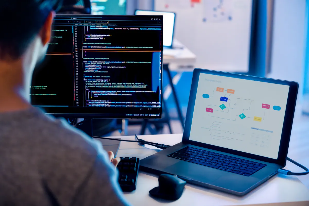 Stock image depicting a software developer working on a computer screen.