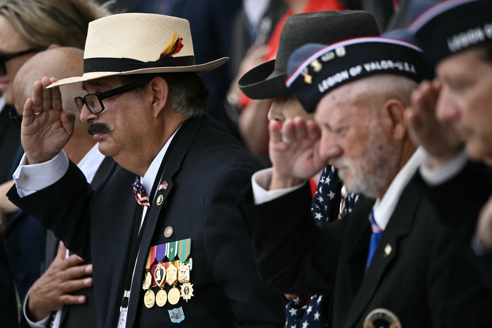 Veterans salute in the amphitheatre at the Tomb of the Unknown Soldier at the start of a ceremony in Arlington National Cemetery in Arlington, Virginia, on Memorial Day, May 26, 2025. (Photo by Brendan SMIALOWSKI / AFP) (Photo by BRENDAN SMIALOWSKI/AFP via Getty Images)