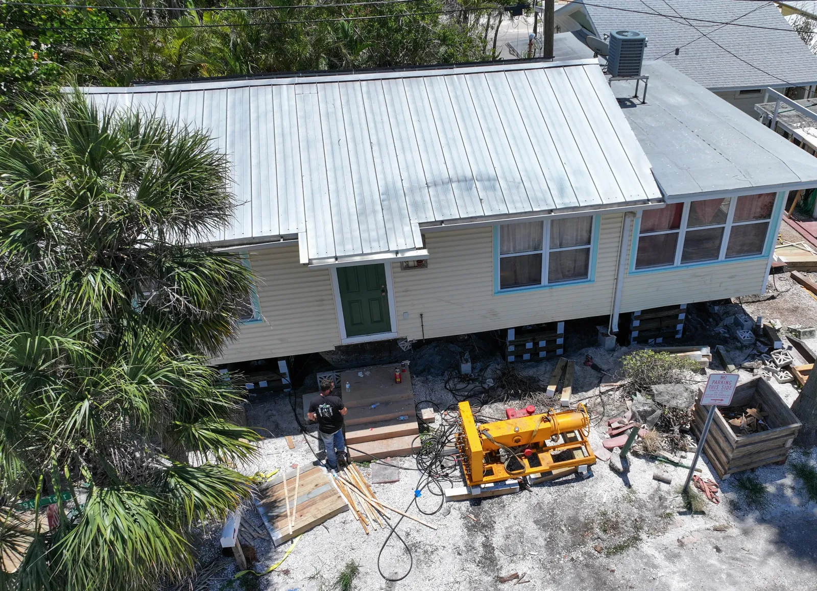An aerial view of workers from JAS Builders and Payne Construction Services raising a home with jacks and framing material in Treasure Island, Florida in May 2025.
