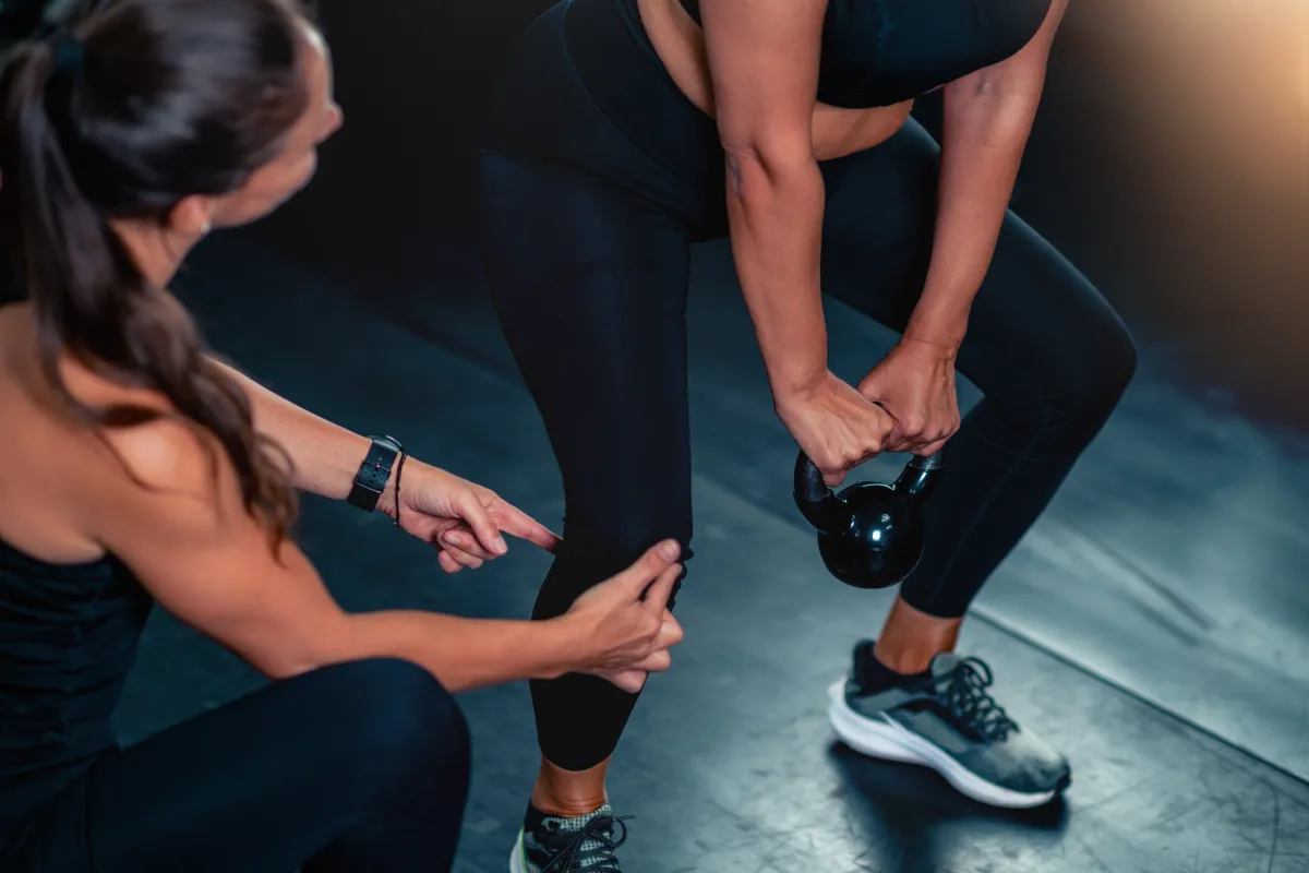 Stock image a gym-goer training with a personal trainer.