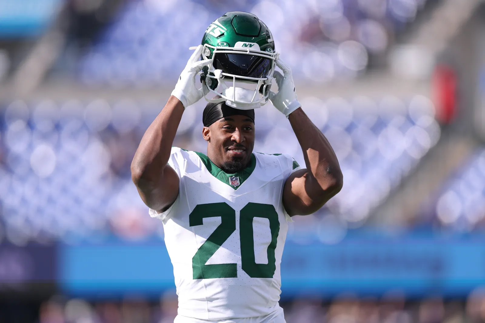 Breece Hall #20 of the Jets taking his helmet off.