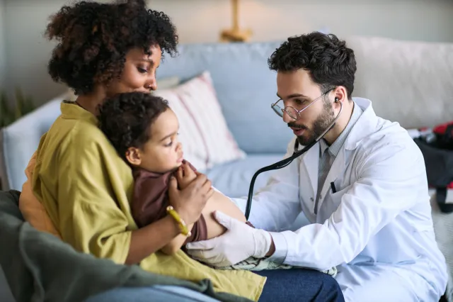 A stock image of a doctor assessing a young child.