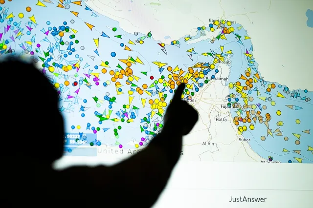 A person points in front of a large screen displaying vessel movements in the Strait of Hormuz on a ship-tracking website, on May 4, in Nicosia, Cyprus.