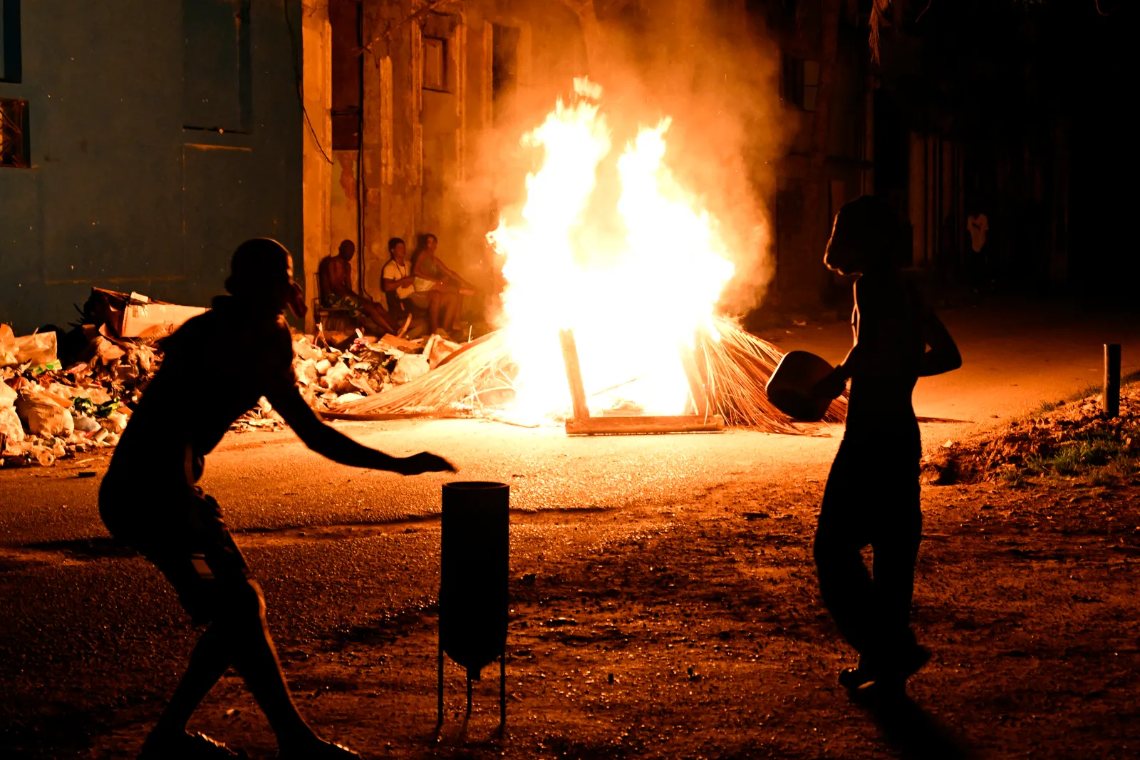 Demonstrators bang pots past a fire set during a protest against the lack of energy and blackouts, in the Lawton neighborhood of Havana on May 14.