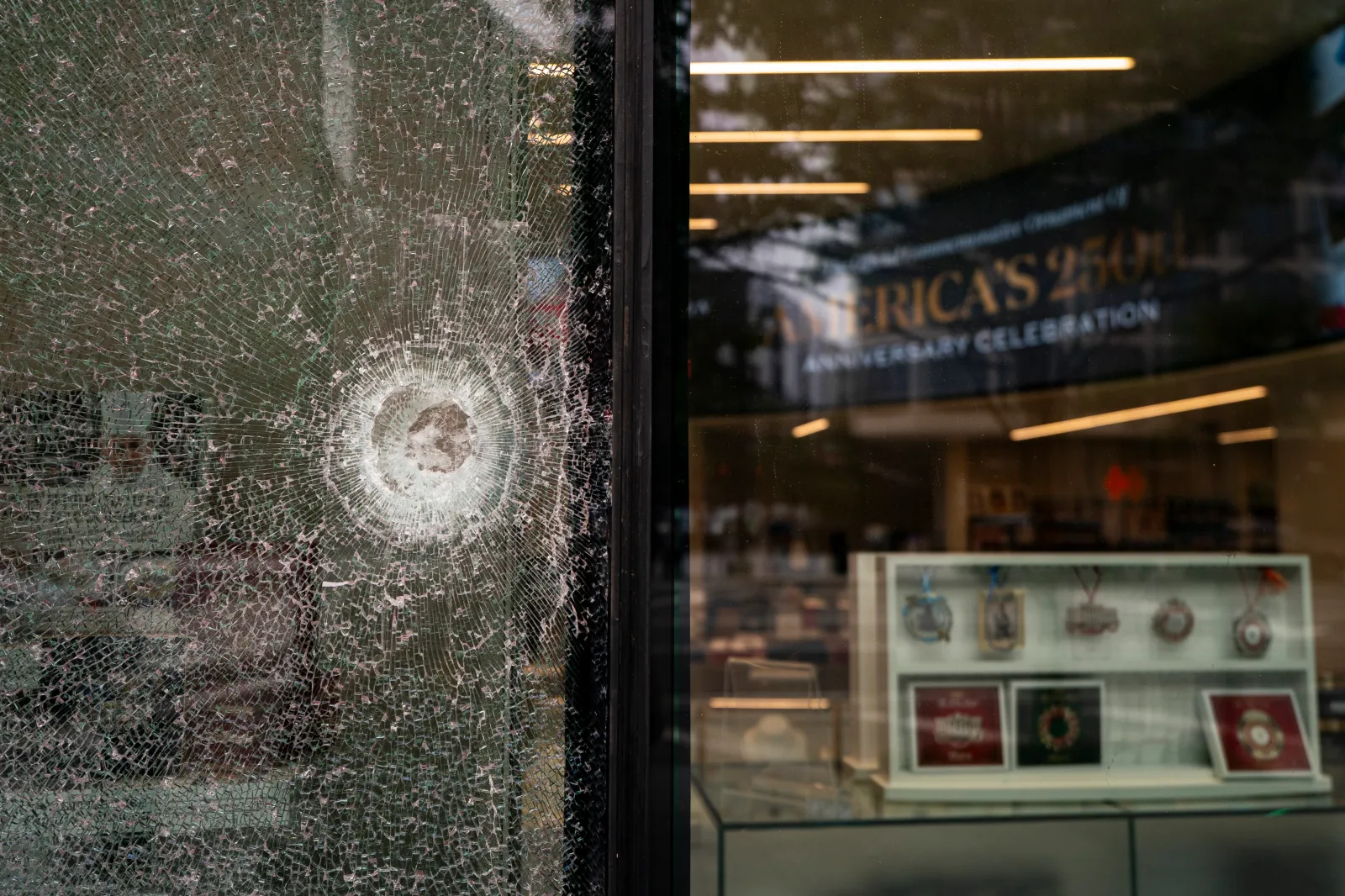 A shattered window of The People's House: A White House Experience, after the weekend shooting near the White House in Washington, D.C.
