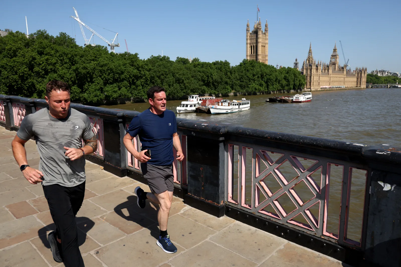 Two men run across Lambeth Bridge in London, England on May 26, 2026.