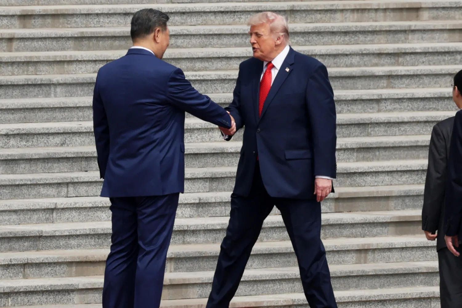 President Donald Trump, right, is greeted by Chinese President Xi Jinping during a welcome ceremony at the Great Hall of the People on May 14, 2026, in Beijing.