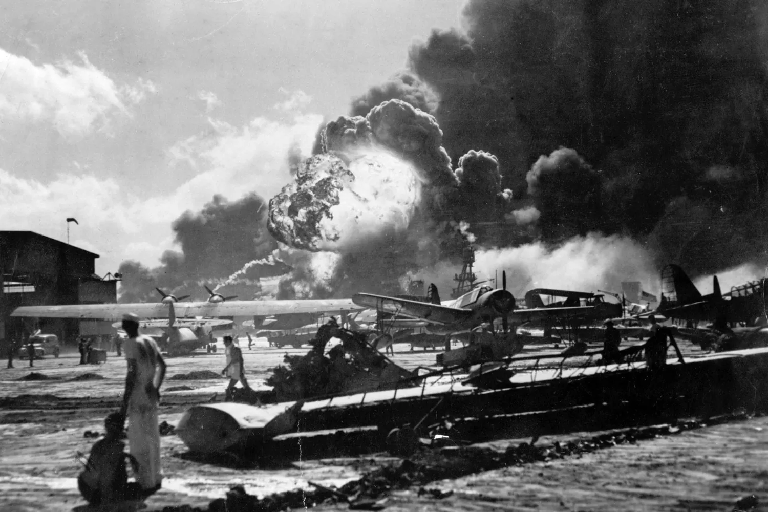 U.S. sailors stand amid wreckage watching as the