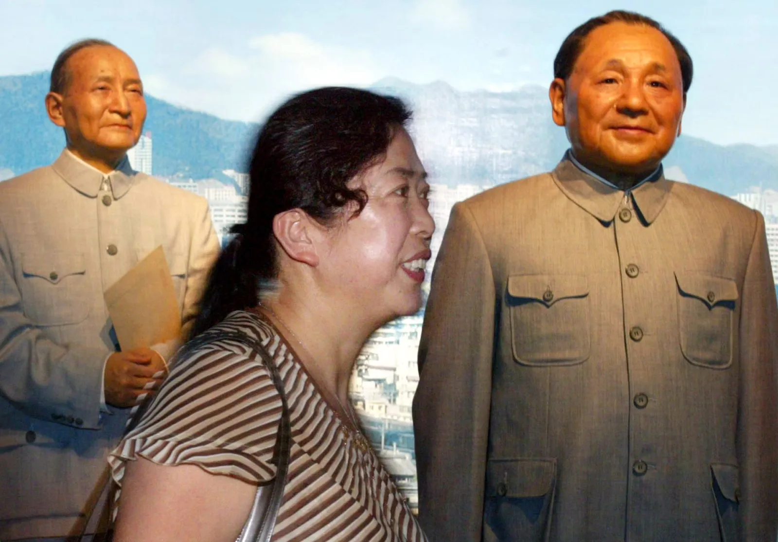 In this historical image, a Chinese woman walks past wax figures of former Chinese leaders Chen Yun, left, and Deng Xiaoping at a Wax Museum in Beijing in 2002. (AP Photo/Ng Han Guan)