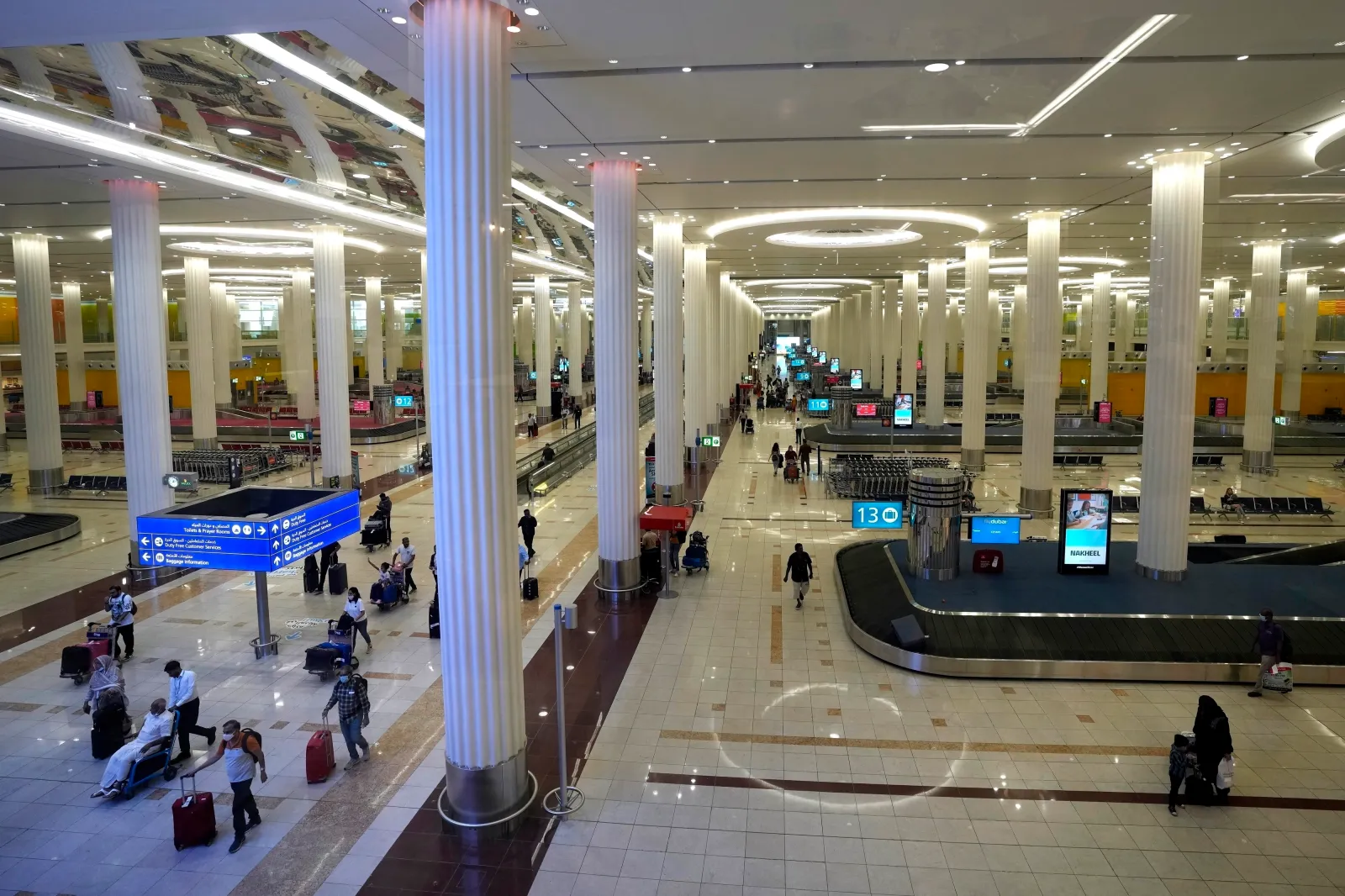 Passengers leave the baggage handling hall at the Dubai International Airport Terminal 3 on October 25, 2022. (AP Photo/Kamran Jebreili, File)