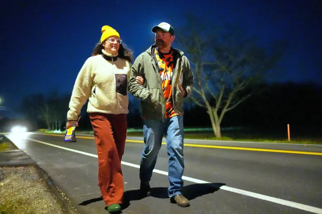 Graham Plattner e Amy Gertner caminham no acostamento da estrada enquanto defendem uma iniciativa de cidadão no dia da eleição, terça-feira, 4 de novembro de 2025, em Ellsworth, Maine.