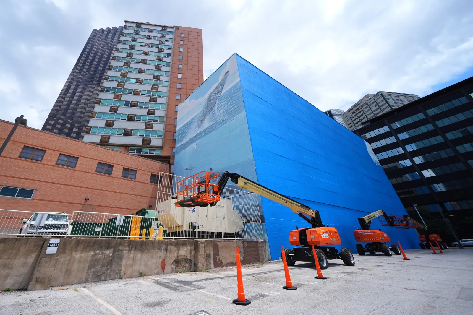 A section of a mural, known as "Whaling Wall 82," created by artist Wyland, is visible as part of it on the right side of the building was painted over, on May 18 in Dallas. (AP Photo/Julio Cortez)
