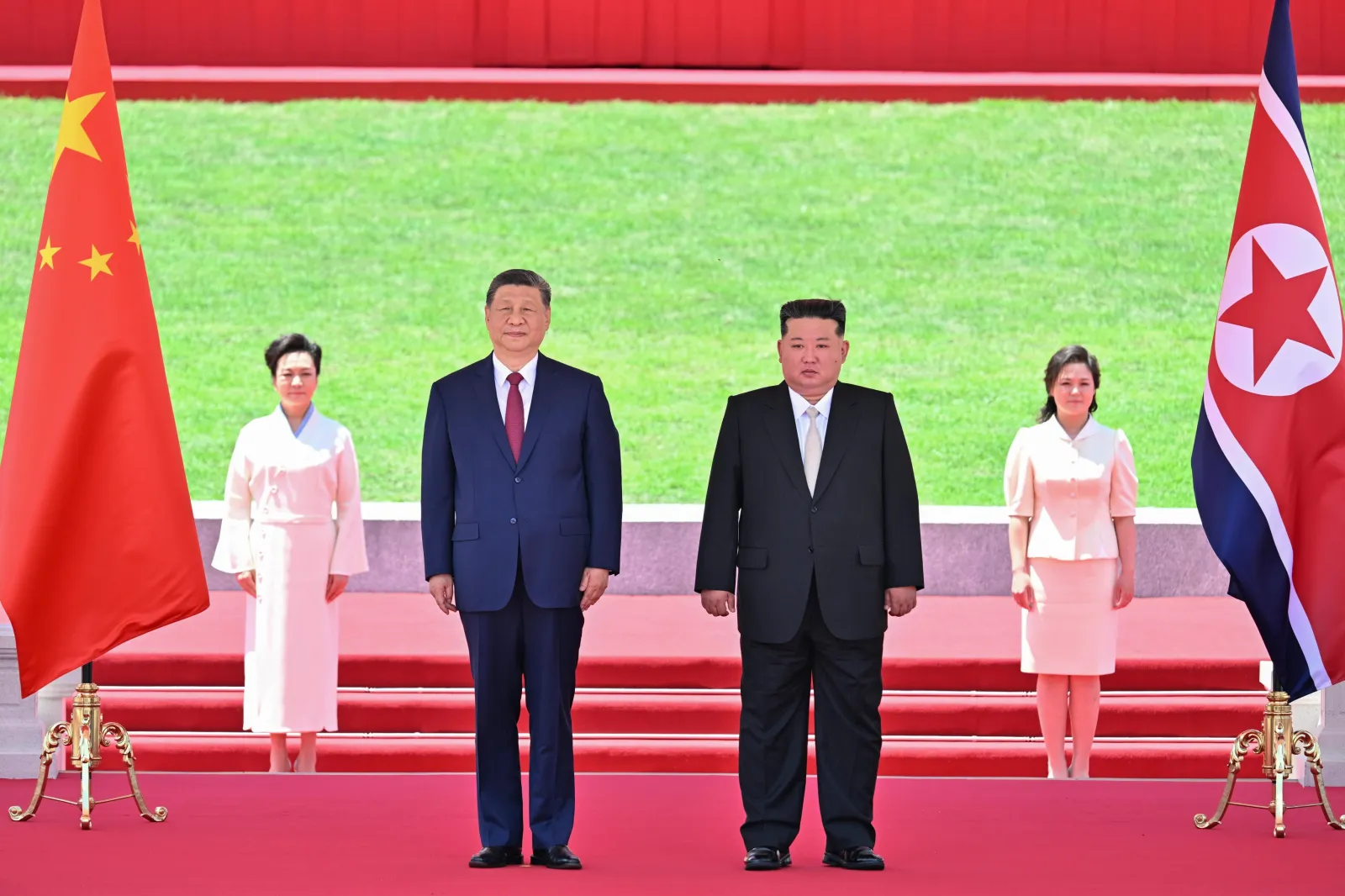 Sur cette photo publiée par l'agence de presse Xinhua, le président chinois Xi Jinping, au centre gauche, et le dirigeant nord-coréen Kim Jong Un regardent une marche militaire lors d'une cérémonie de bienvenue à Pyongyang le 8 juin 2026.