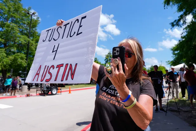 A woman holds a sign in front of the Collin County courthouse after the verdict was reached in the Karmelo Anthony trial on June 9, 2026 in McKinney, Texas.