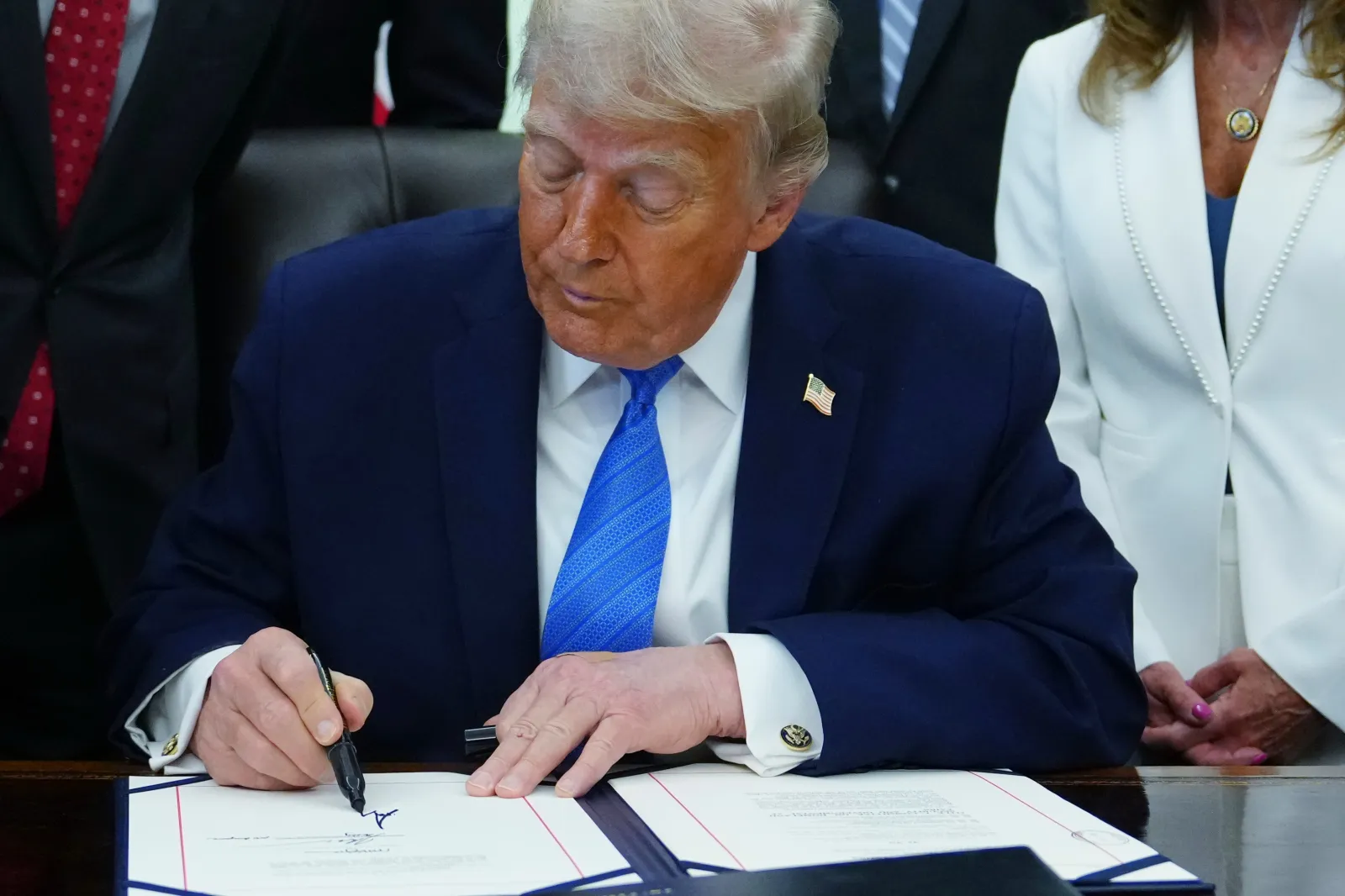 President Donald Trump signs a bill funding immigration enforcement in the Oval Office of the White House, Wednesday, June 10, 2026, in Washington. (AP Photo/Julia Demaree Nikhinson)